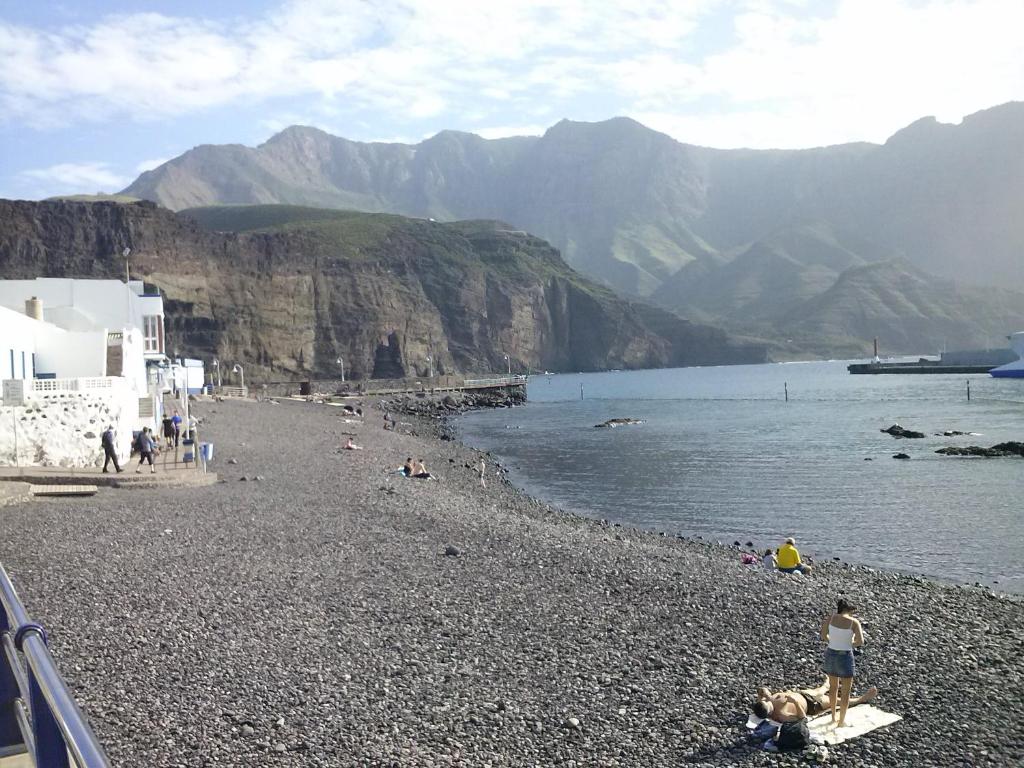 a group of people on a beach near the water at Casa Lola in Agaete