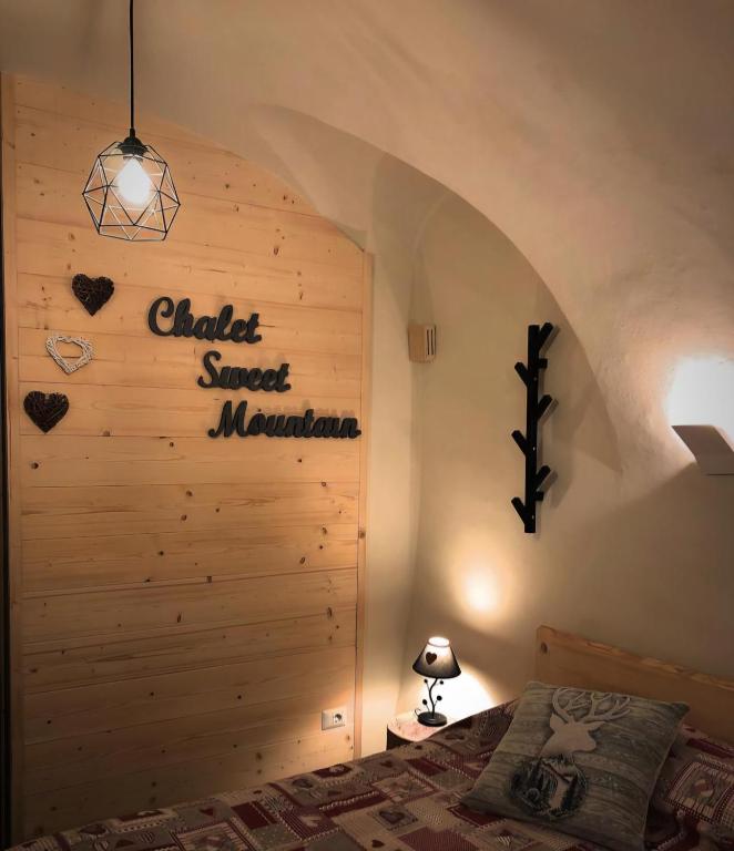 a bedroom with a wall that says camel sweet mountain at Chalet Sweet Mountain in Ponte di Legno