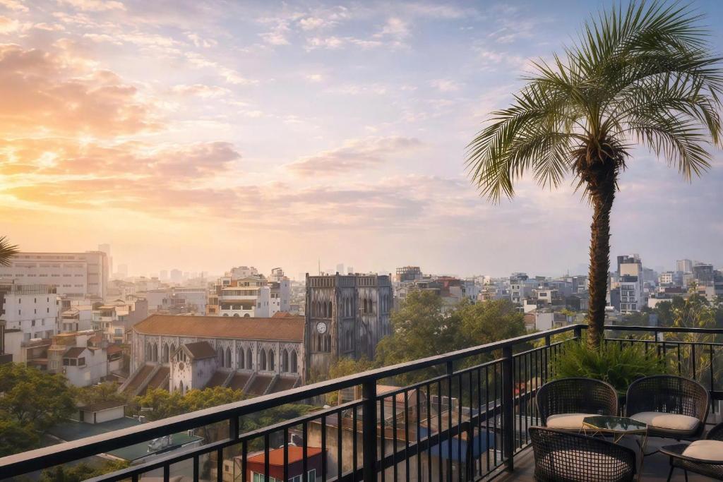 a view of a city from a balcony with a palm tree at The Chi Boutique Hotel in Hanoi