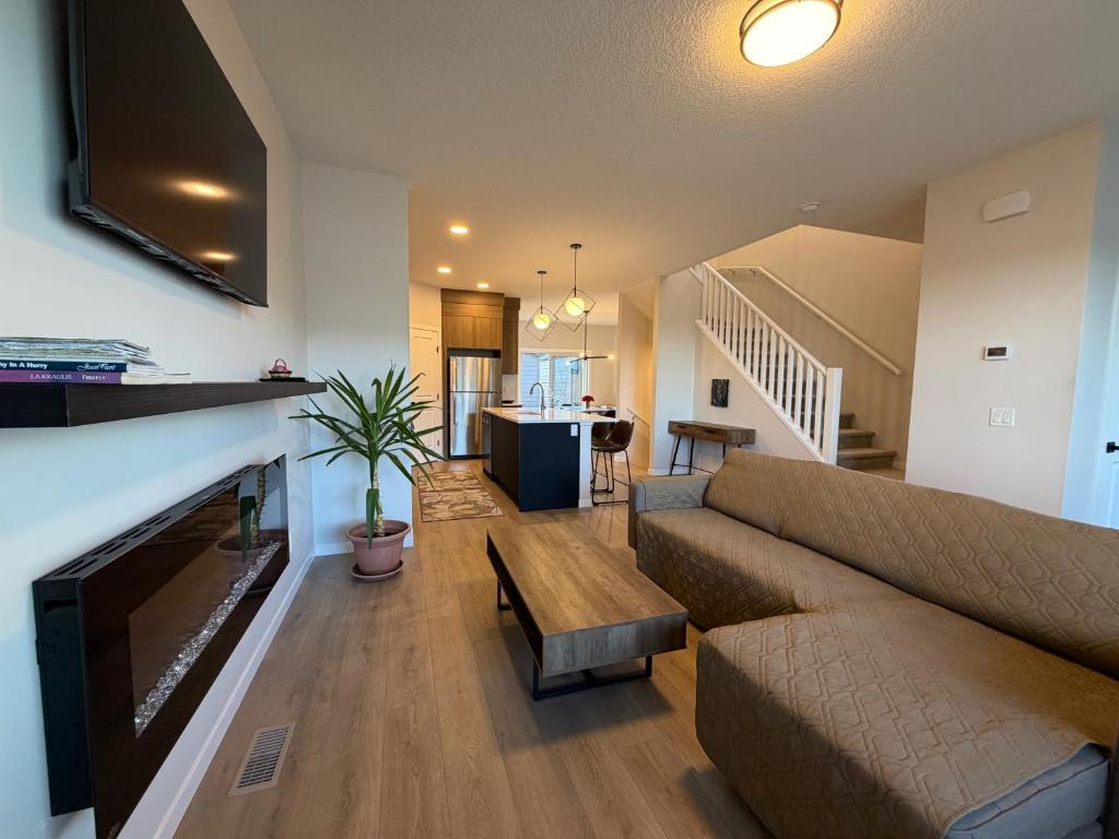 a living room with a couch and a fireplace at Beautiful New House in Alpine Park, Calgary in Calgary