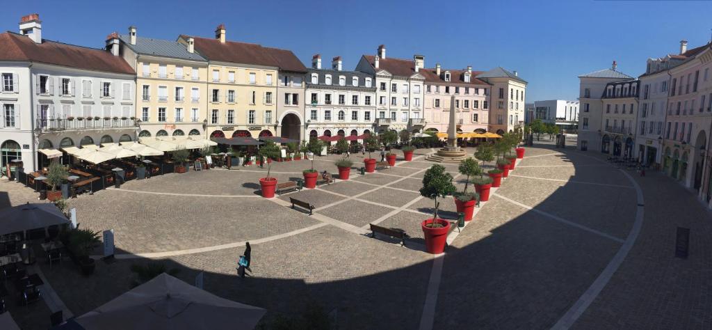 a city street with buildings and a courtyard with trees at Appartement near Disneyland in Serris