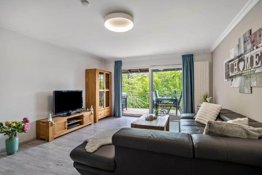 a living room with a couch and a tv at Ferienwohnung Sauerland an der Ruhr in Olsberg
