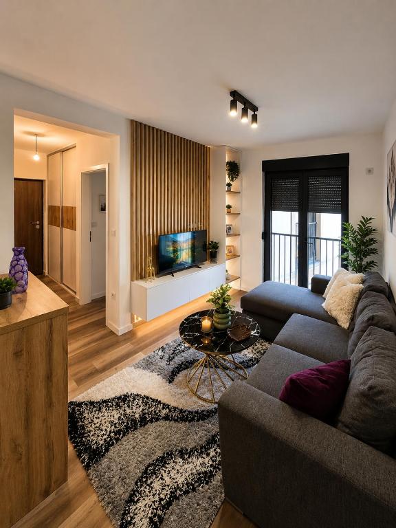 a living room with a couch and a tv at Urban Nest Tuzla in Tuzla