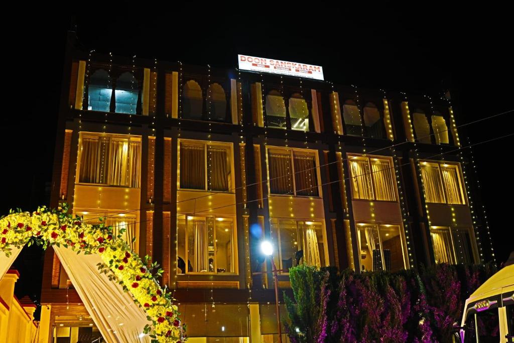 a building at night with a bunch of lights at Doon Sanskaram Hotel in Chūharpur