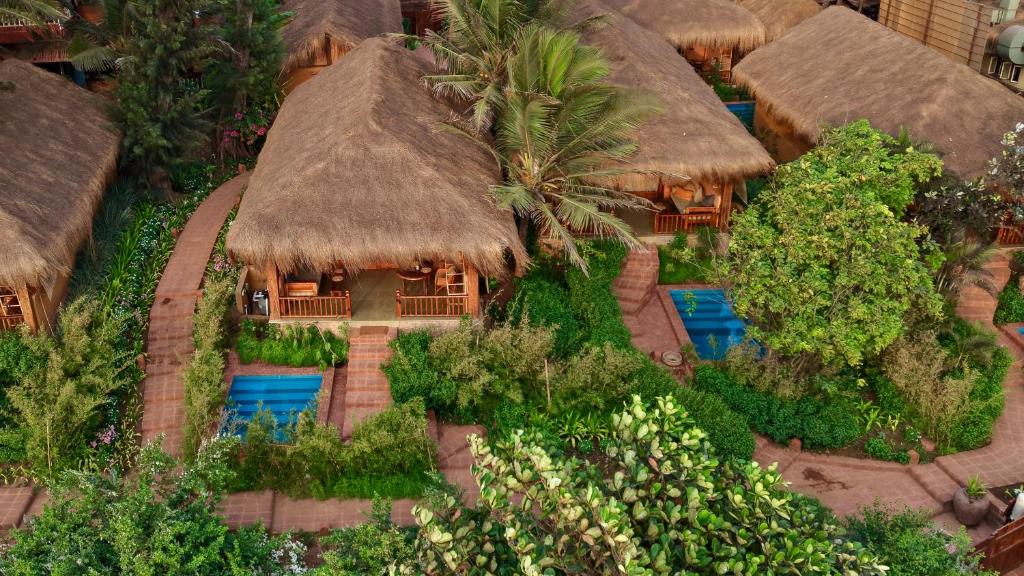 a model of a resort with grass roofs and trees at Palm Grove Beach Resort in Mandrem