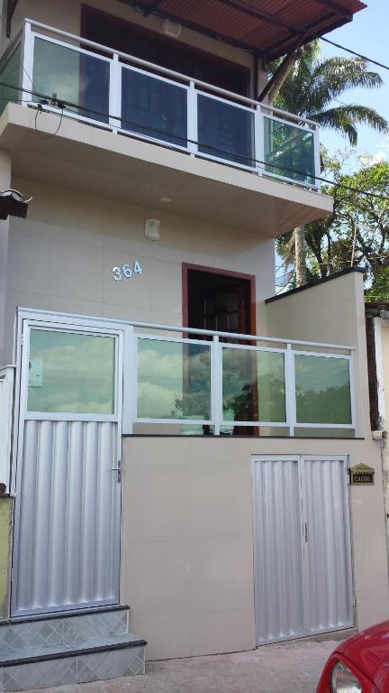 een wit huis met een poort en een balkon bij Apartamento Central in Guaramiranga