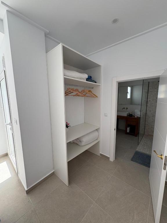 a white room with a bathroom with a closet at Beau séjour in Pedreguer