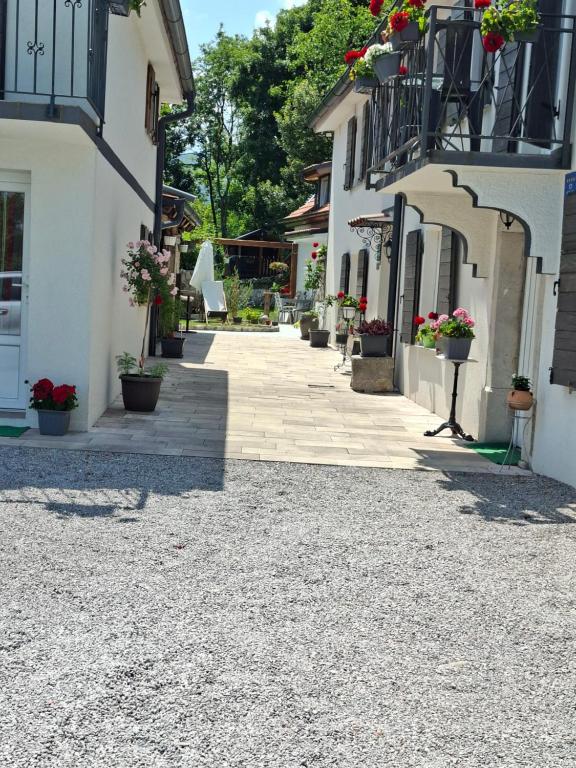 a stone walkway between two buildings with potted plants at Kameni biser in Jurdani