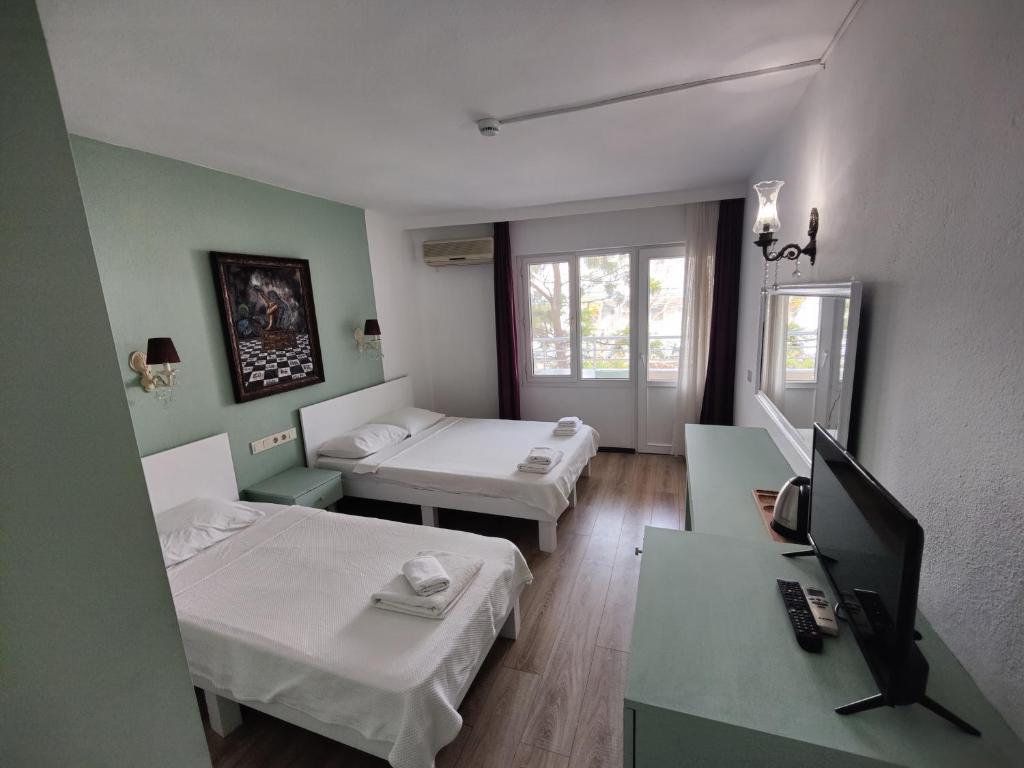 a room with two beds and a television in it at Datça Stayinn Otel in Datca