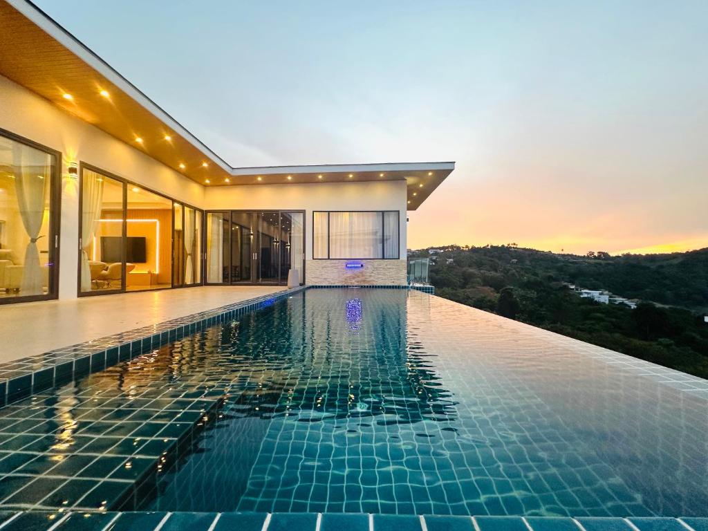 a swimming pool in a house with a sunset in the background at Ocean Big Tiger Villa-6 Bedrooms with Ocean View Private Pool in Nathon Bay