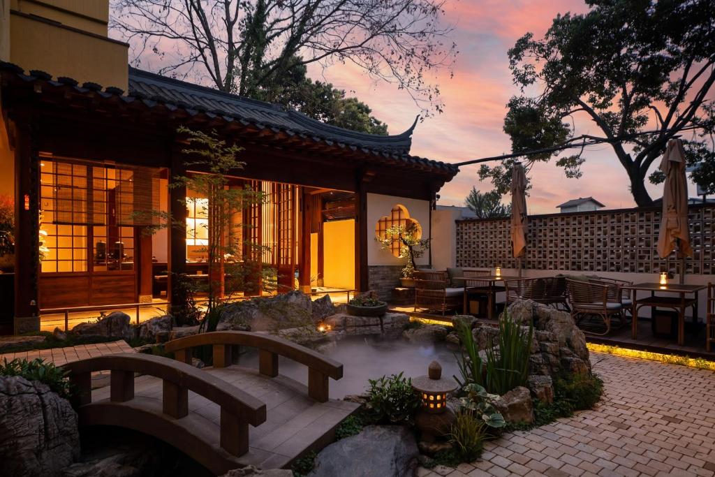 a backyard with a hot tub and a house at Liaoxin Valley Forest Hotel in Jiezi Ancient Town