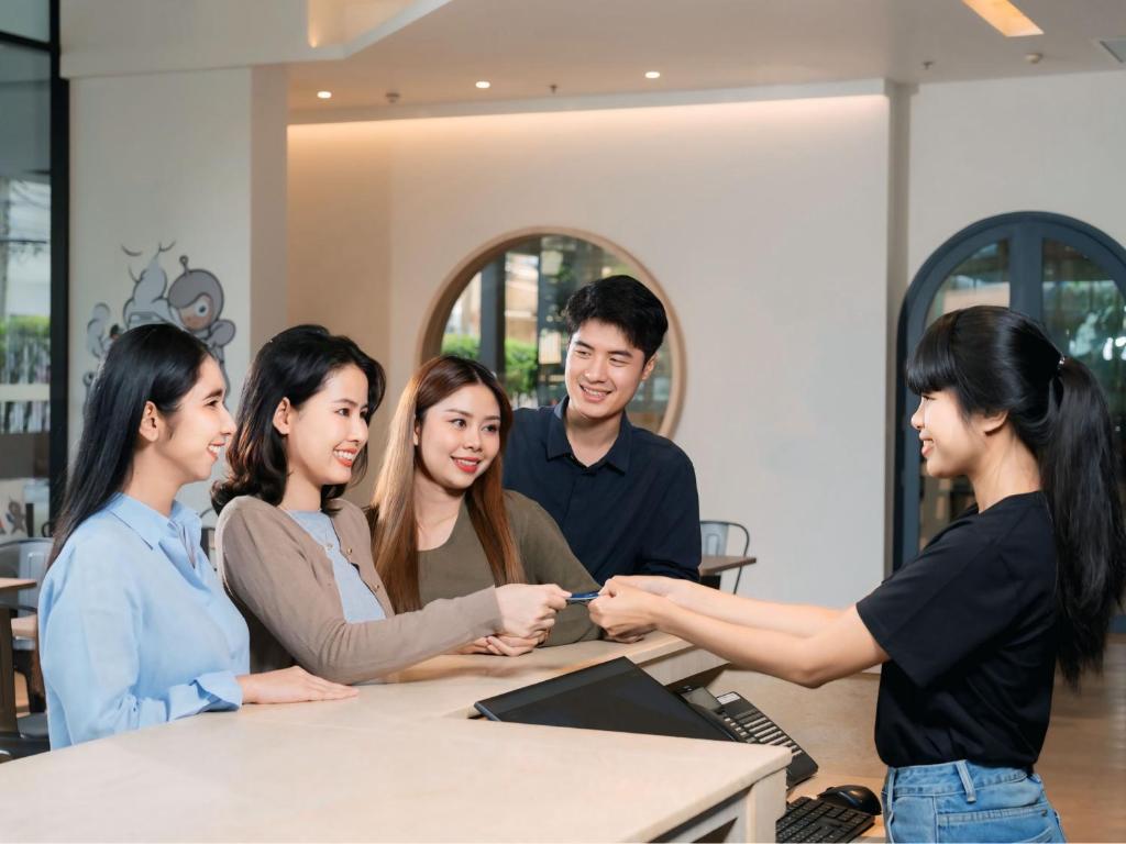 A group of guests is shown being welcomed at the hotel reception counter.
