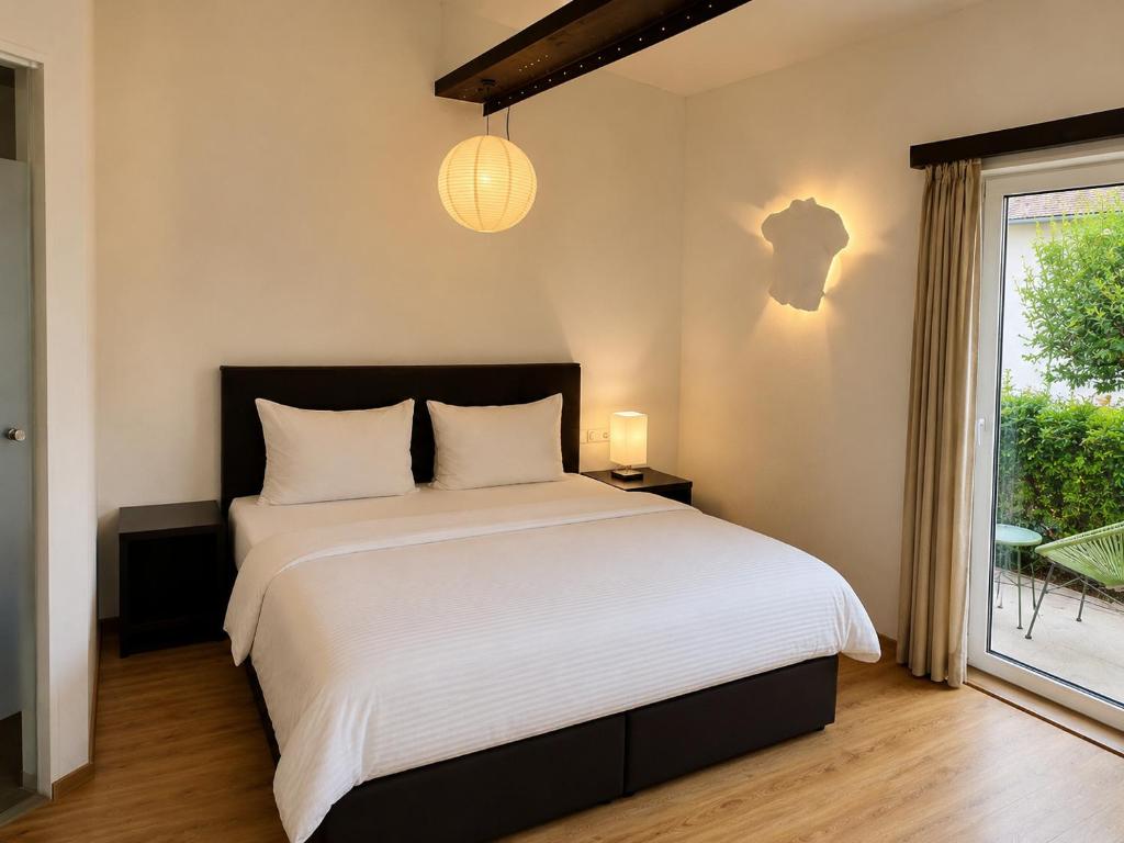 a bedroom with a large white bed and a window at S'Matt Bob in Feldkirch