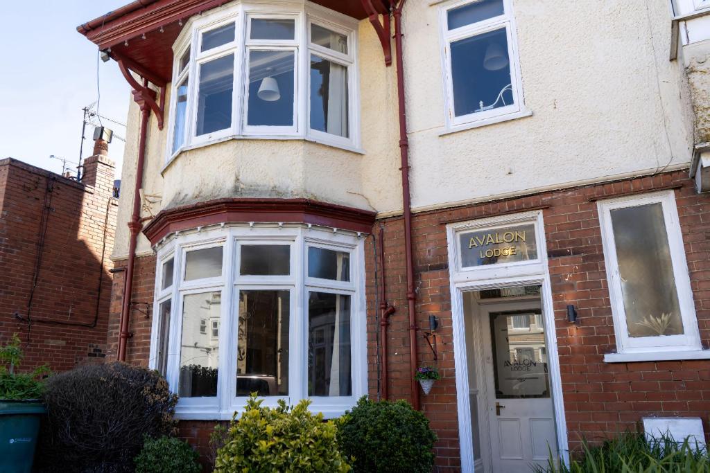 a brick building with white windows and a storefront at Avalon Lodge in Bridlington