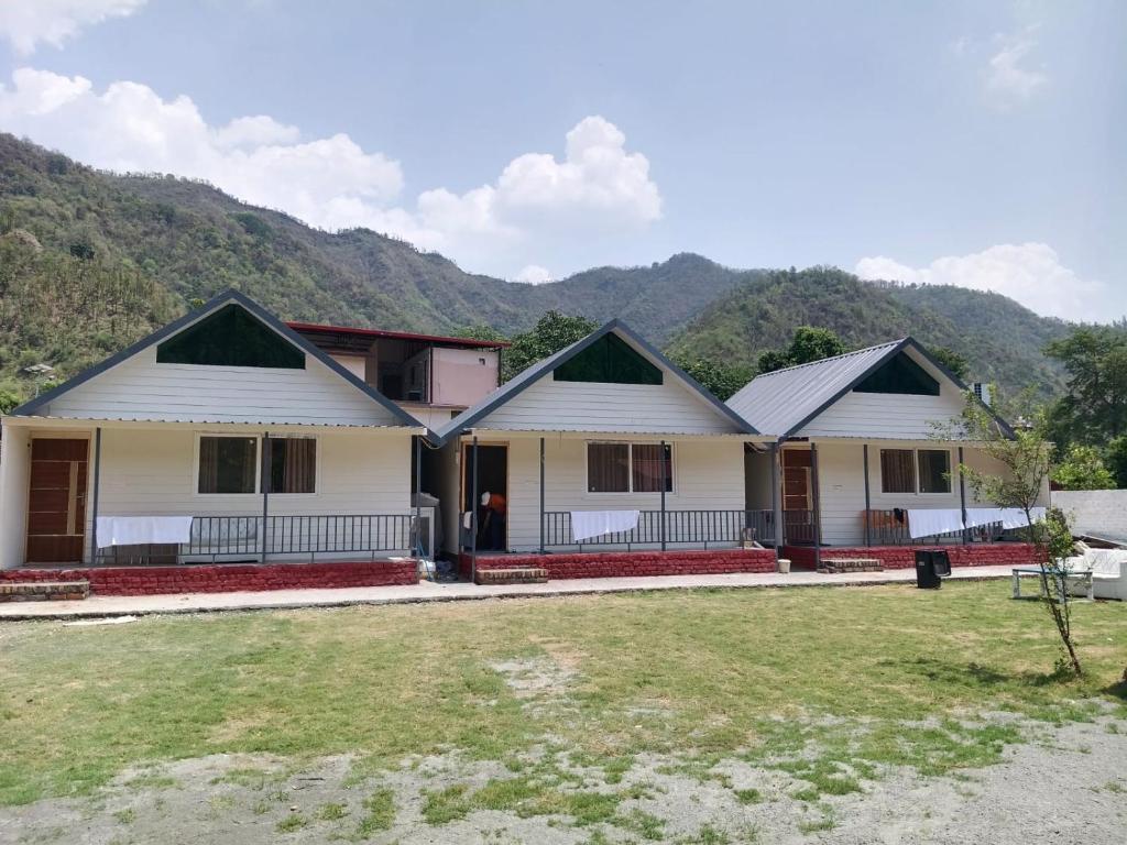 a row of houses with mountains in the background at Petals Cafe & Resort in Rājpur
