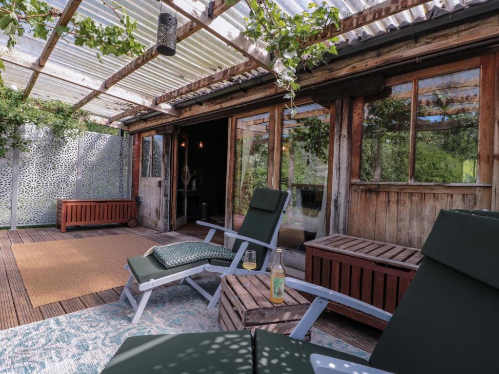 a screened in porch with two chairs and a bench at Ferryman's Lodge in Chepstow