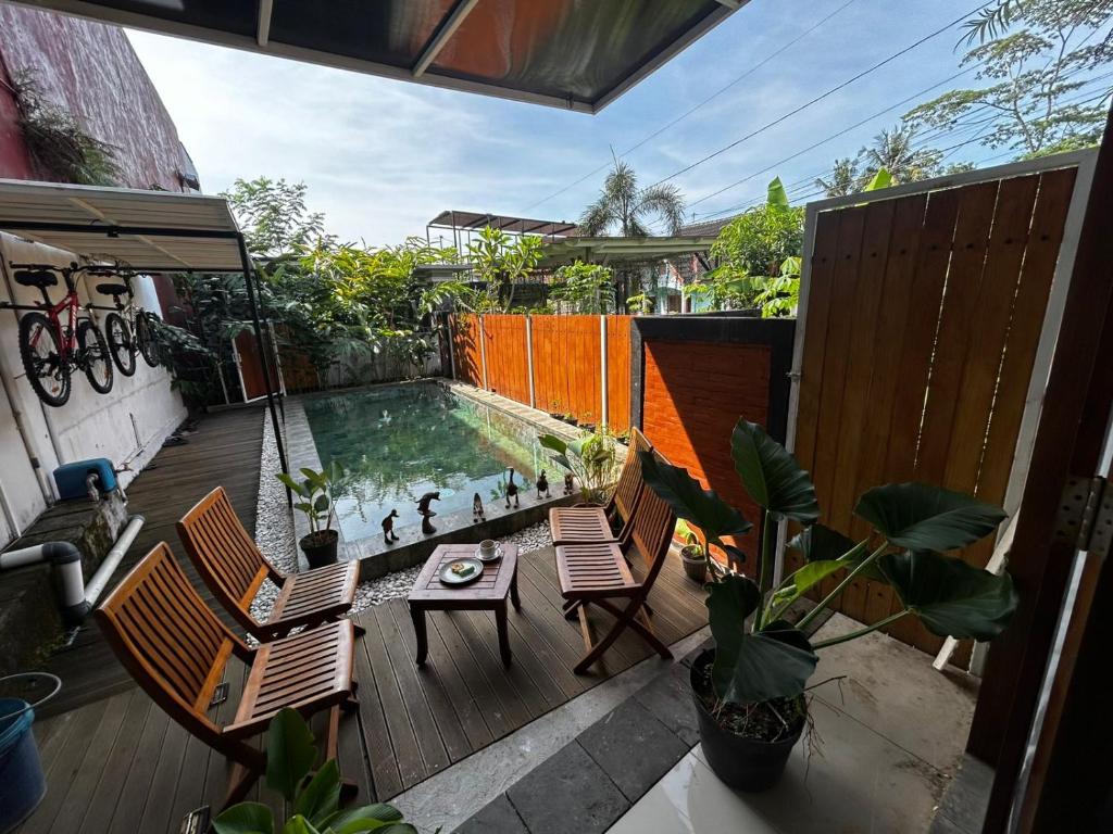 a patio with a table and chairs and a swimming pool at Villa Kecombrang in Salakan