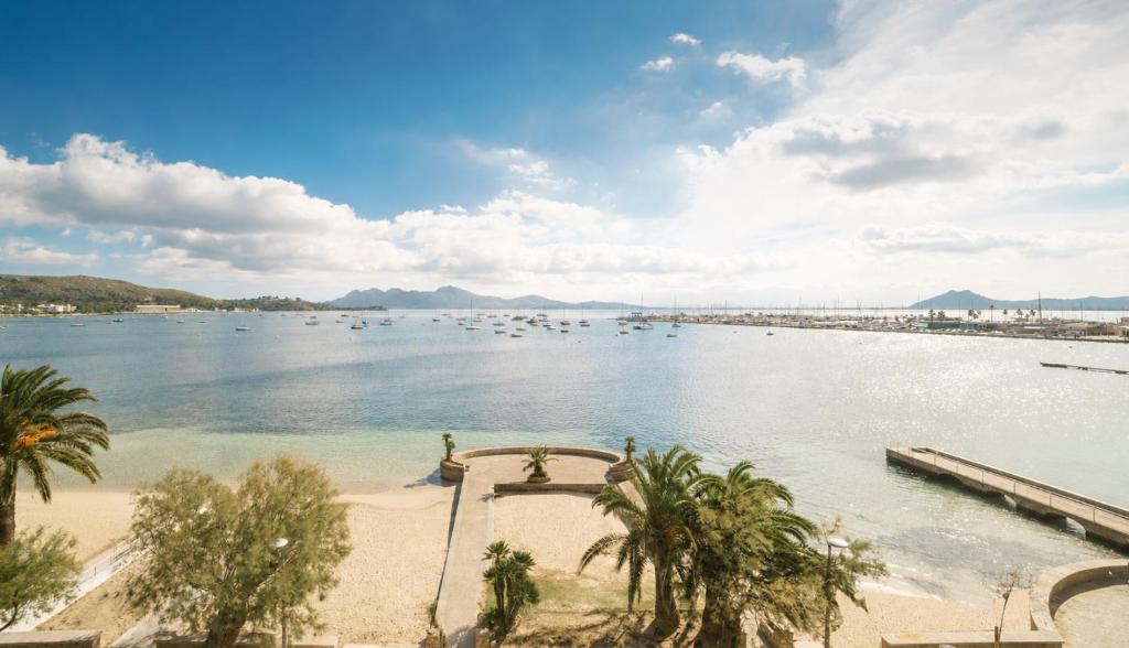 a beach with a bunch of boats in the water at Hotel Capri Pollensa in Port de Pollensa