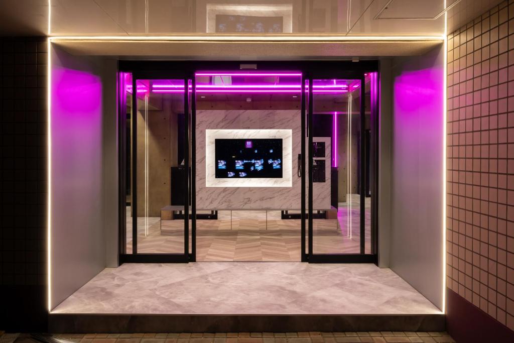 a hallway with purple lights and a mirror at ホテルリノ in Kitakyushu