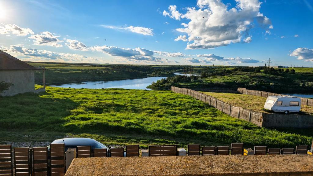a view of a river with a trailer and a fence at Vis de Primăvară, vilă întreagă cu 4 dormitoare și vedere la lac in Limanu