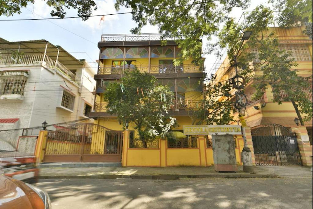 a yellow building with a sign in front of it at Eennra Oiitijhyya in Kolkata