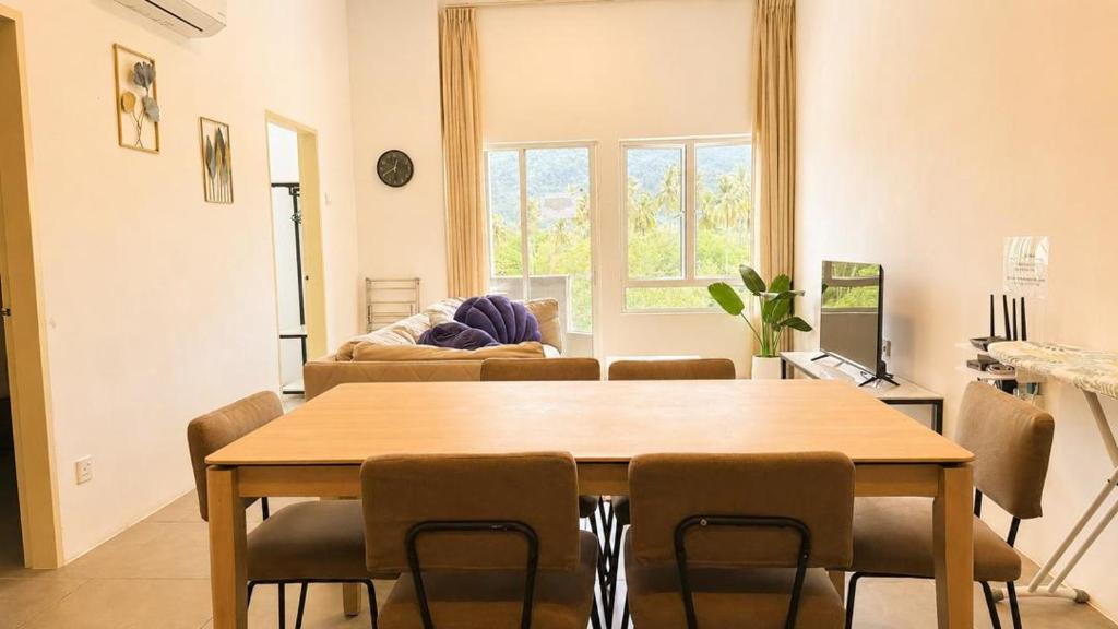 a living room with a wooden table and chairs at Casa Le Dream (03) in Kuah