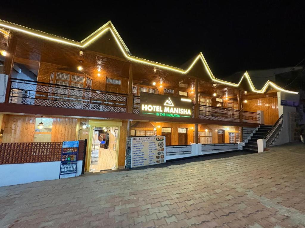 a night view of a hotel with a sign on it at HOTEL MANISHA in Gangotri