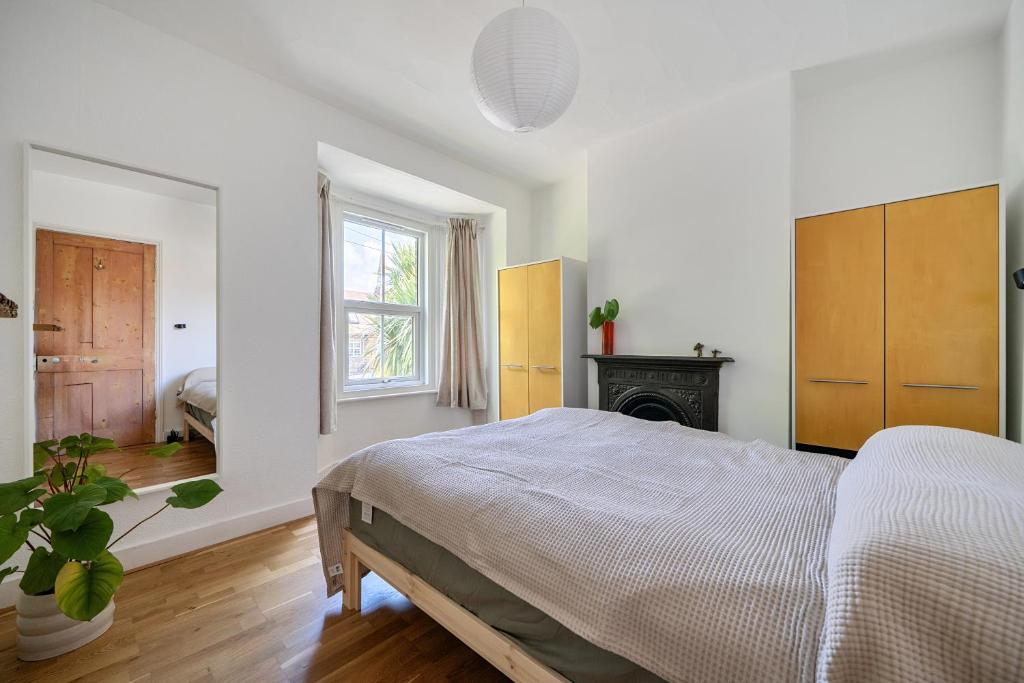 a white bedroom with a bed and a fireplace at Victorian Terrace near Uni sleeps 6 Garden in Reading