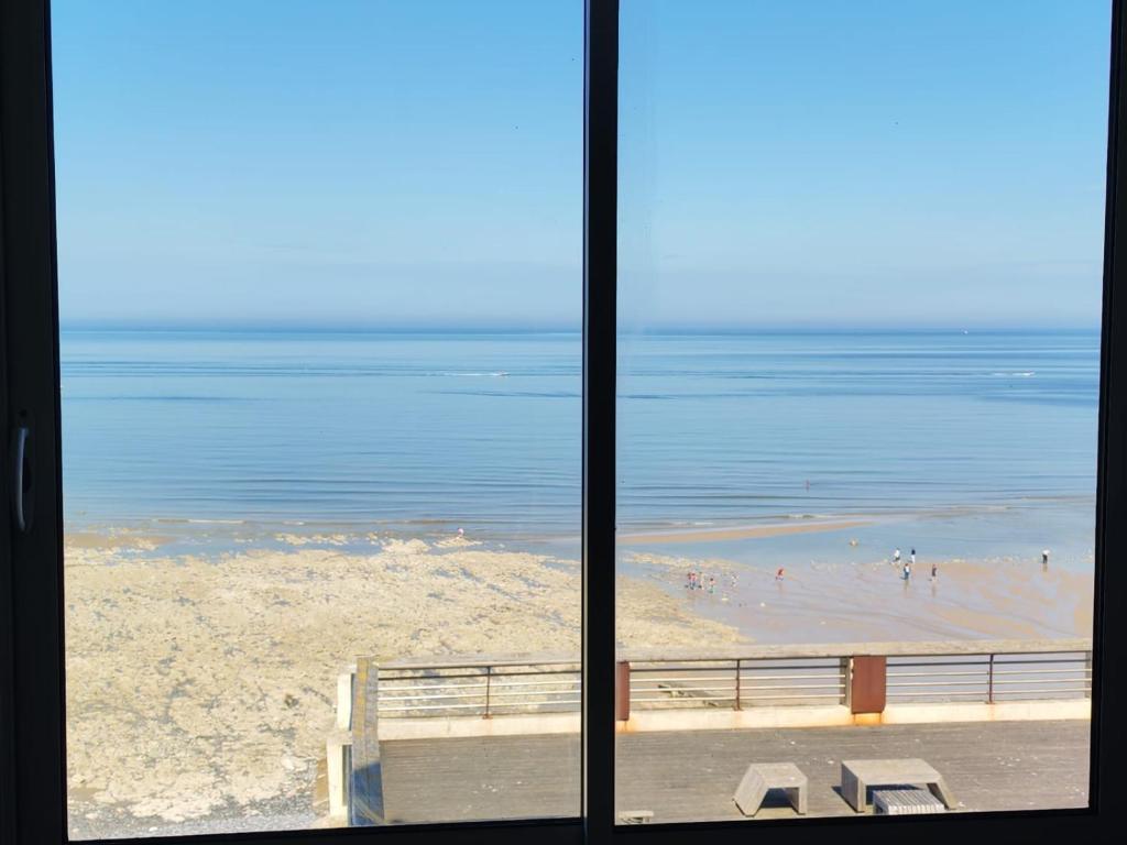 a view of a beach from a window at Appartement Cosy in Ault