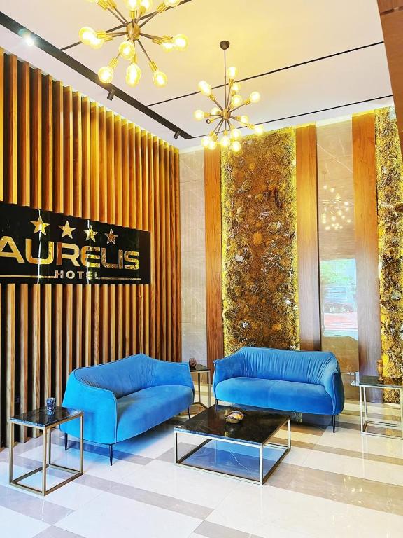 a living room with blue couches and a table at Aurelis Hotel in Bërxull