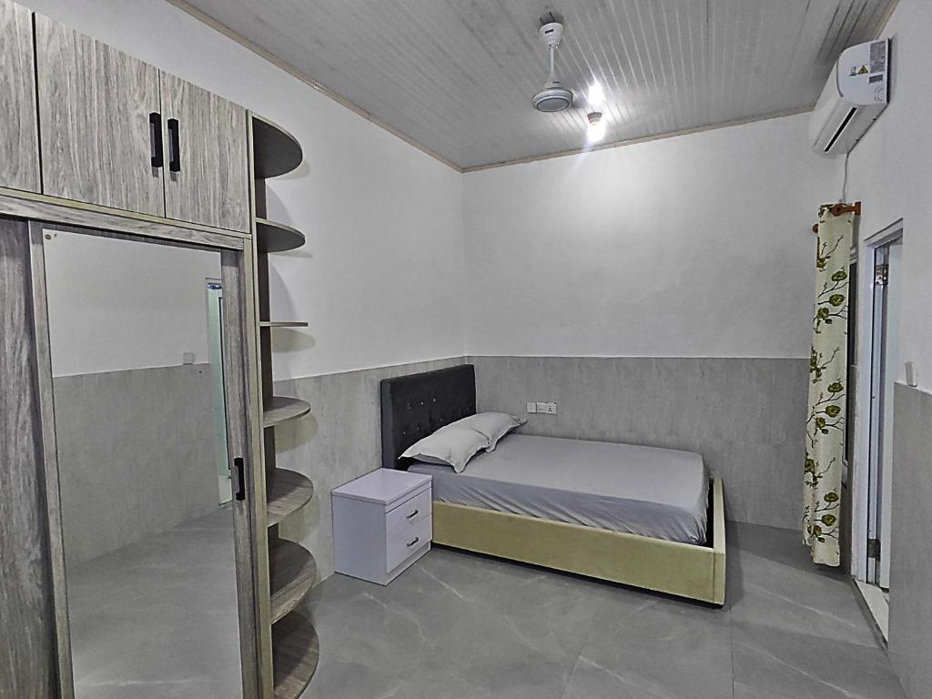a small bedroom with a bed and a staircase at Heena in Kendhoo