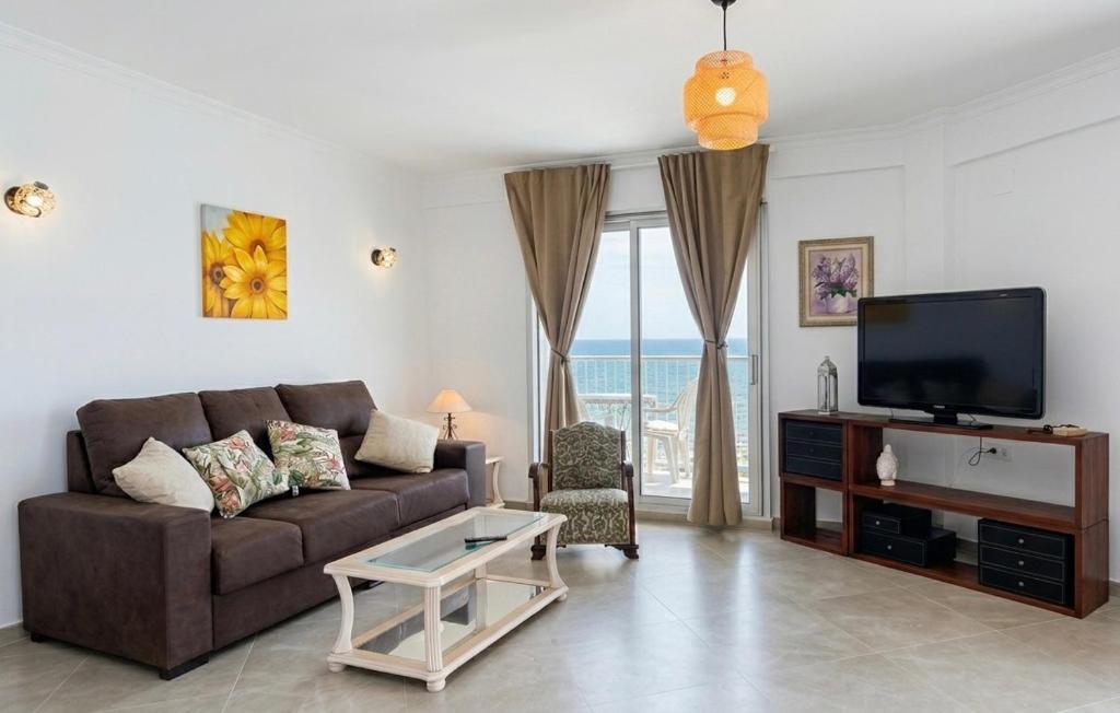 a living room with a couch and a tv at Apartamento con vistas a la Playa con Ascensor y WIFI 9 pax in Daimuz