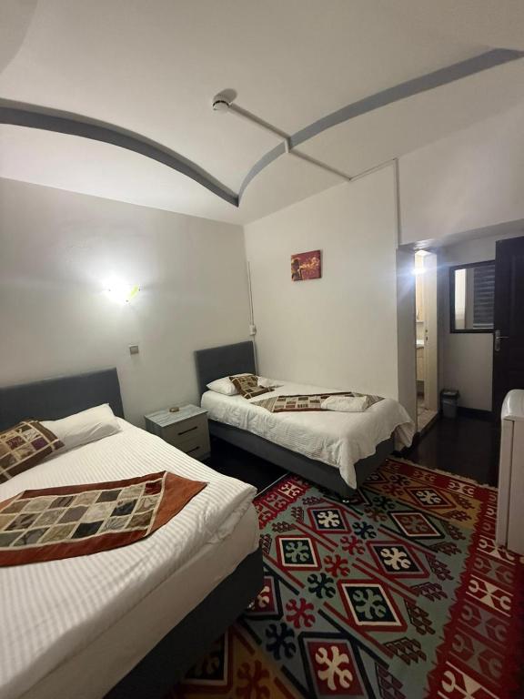 ein Zimmer mit zwei Betten und einem Teppich in der Unterkunft City Hotel in Ayii Trimithias