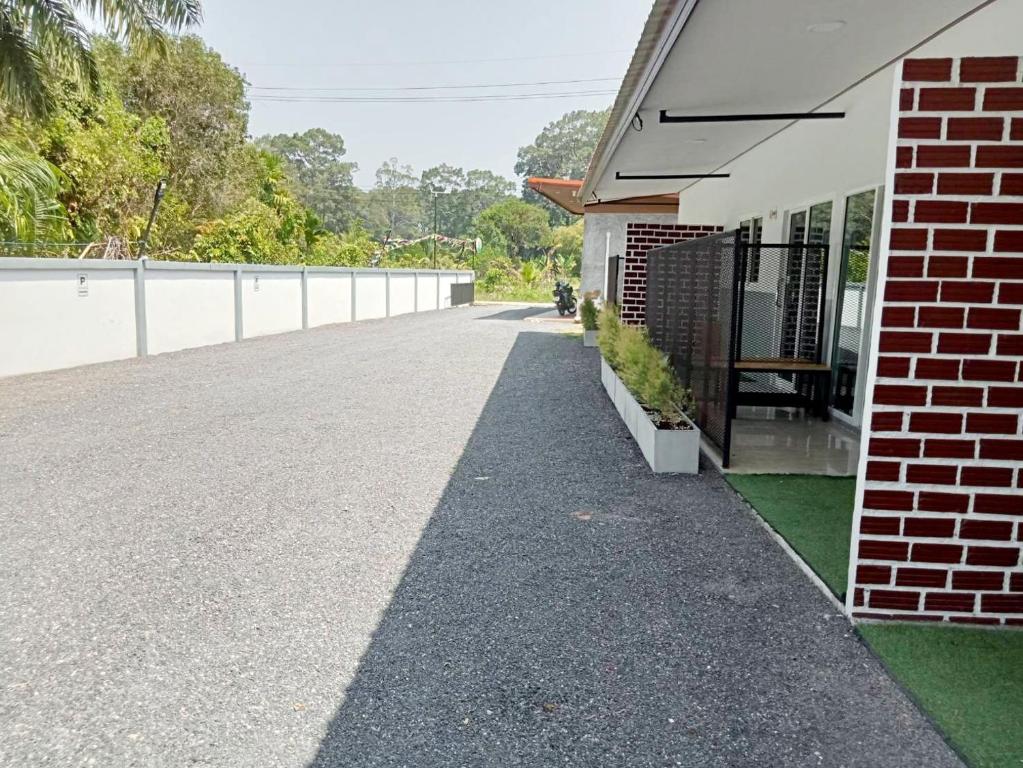 a driveway of a house with a brick building at ทุ่งจับช้างโฮมสเตย์ in Pumriang