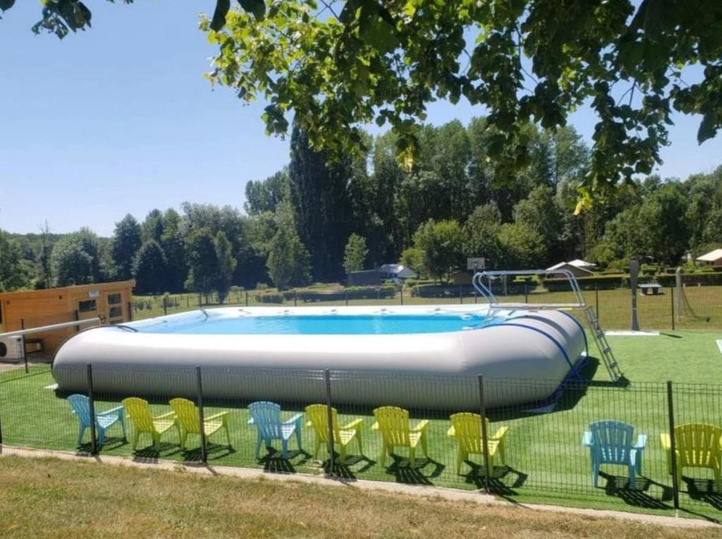 a swimming pool with chairs around it in a park at Camping 3 étoiles - Piscine - ccbgaci in Illiers