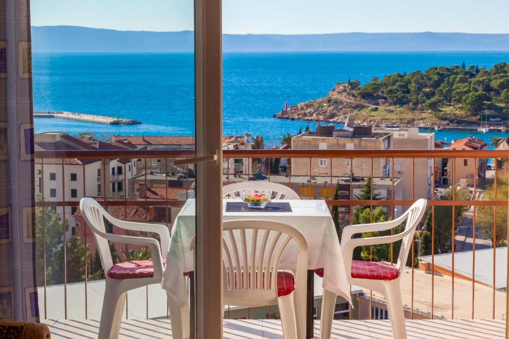 a table and chairs on a balcony with a view of the ocean at City Apartment Mima in Makarska