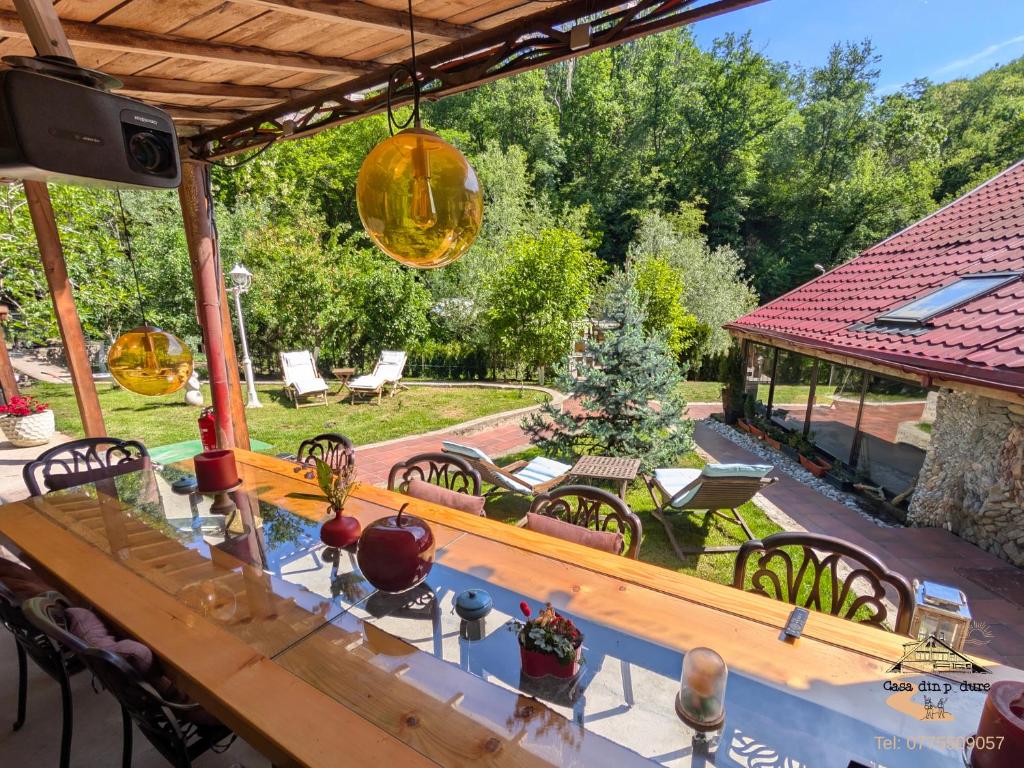 a patio with a table and chairs in a yard at Casa din padure in Orşova