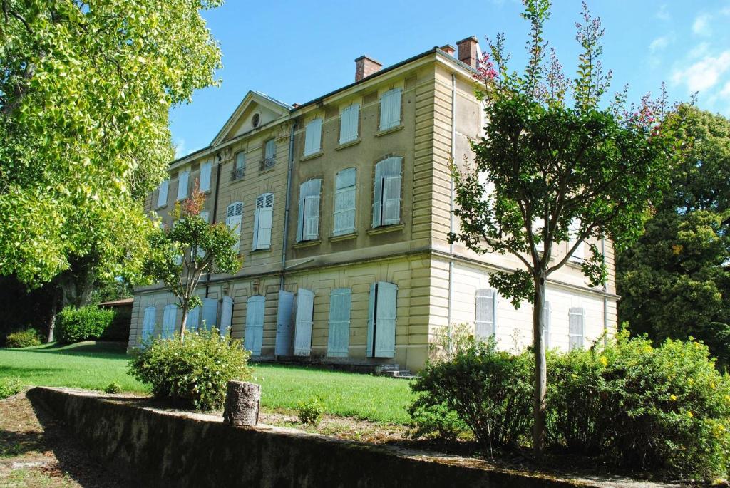 an old house with a tree in front of it at Chateau de Barral - Piscine privée in Hauterives