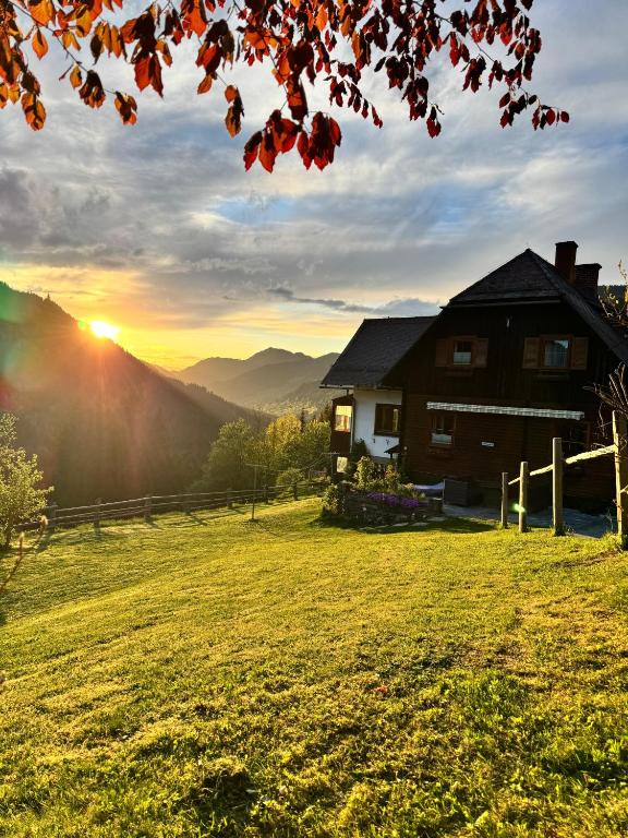 a house on a hill with the sunset in the background at Die Hornbacherin in Rottenmann