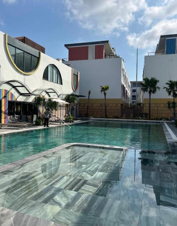 a large swimming pool in a city with buildings at Cozy Corner Beach Hotel in Phú Quốc