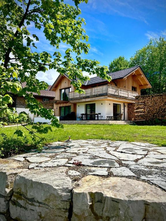 a large house with a stone patio in front of it at SeeChalet Hallstatt in Bad Goisern