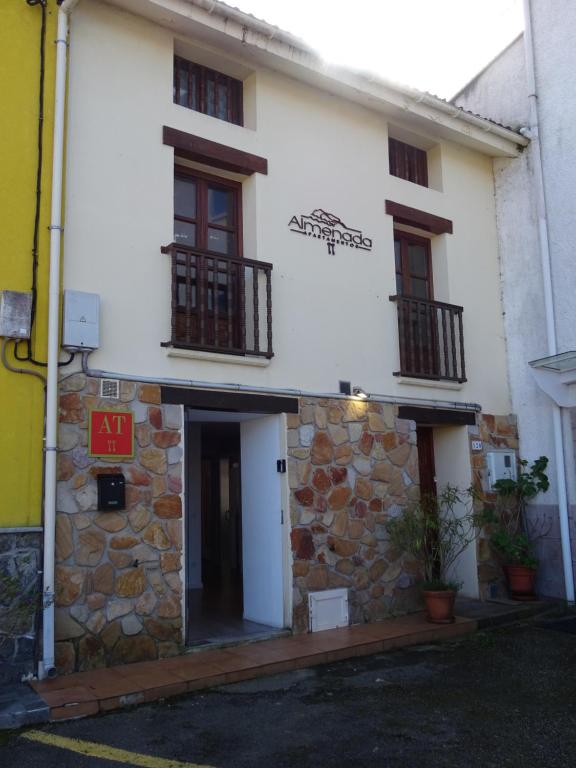 a white building with two balconies on it at Apartamentos Almenada in Llanes