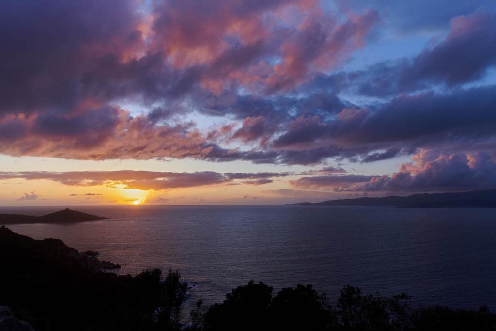 a sunset over a body of water with the sun setting at Fianca l'Osso in Belvédère