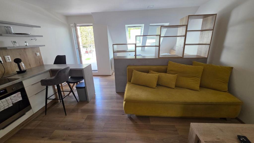 a living room with a couch and a kitchen at Apartmany CityCentrum Trencin in Trenčín