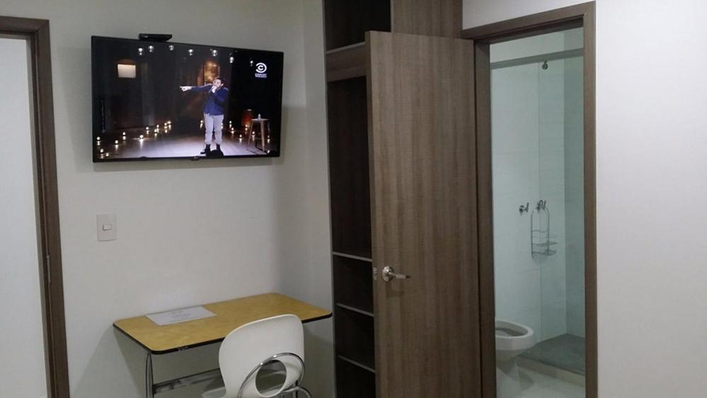 uma casa de banho com uma televisão pendurada na parede em A Bogota On Holidays by Open - HOTEL em Bogotá