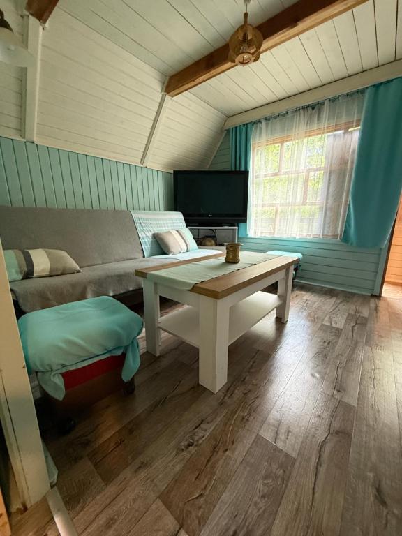 a living room with a couch and a table at Tleniowo Domek in Tleń
