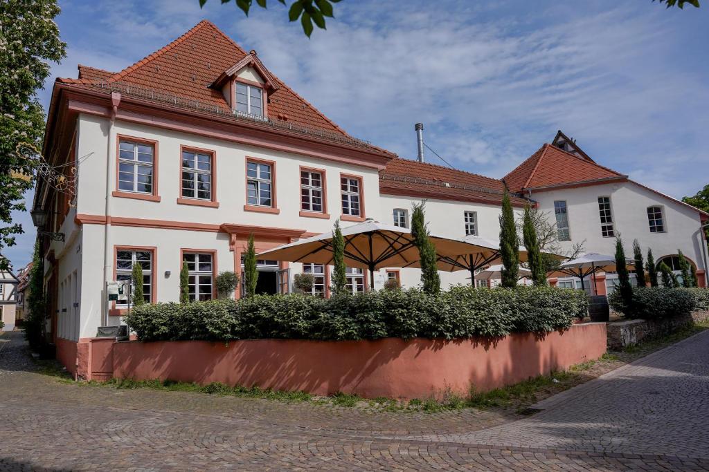 a large white house with a red roof at Wohnkultur - DSIGNIO Ladenburg Digital Hotel in Ladenburg