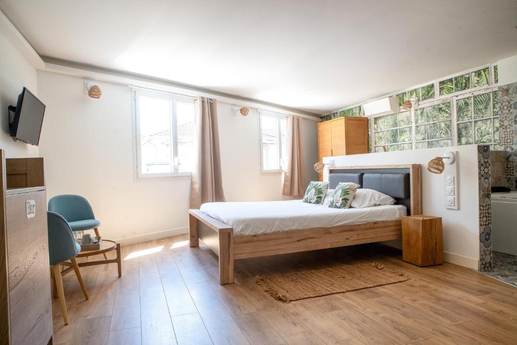 a bedroom with a bed and two windows at Suite Cotinga, balneo, bien-être, Parc des Oiseaux in Villars-les-Dombes