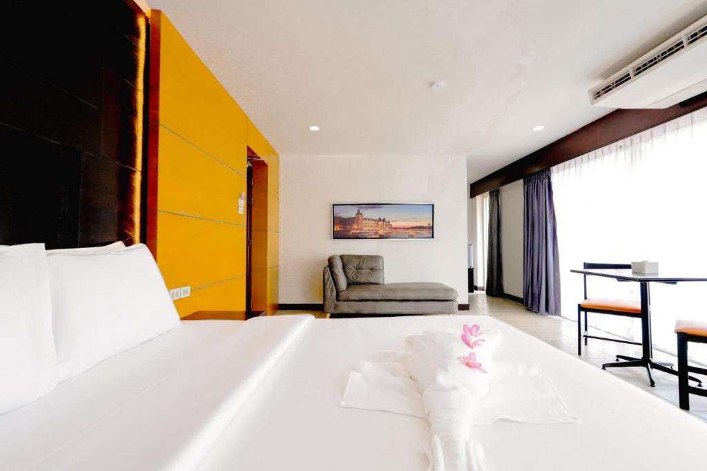 un dormitorio con una cama blanca grande y una silla en Resort by Harsh, en Pattaya central