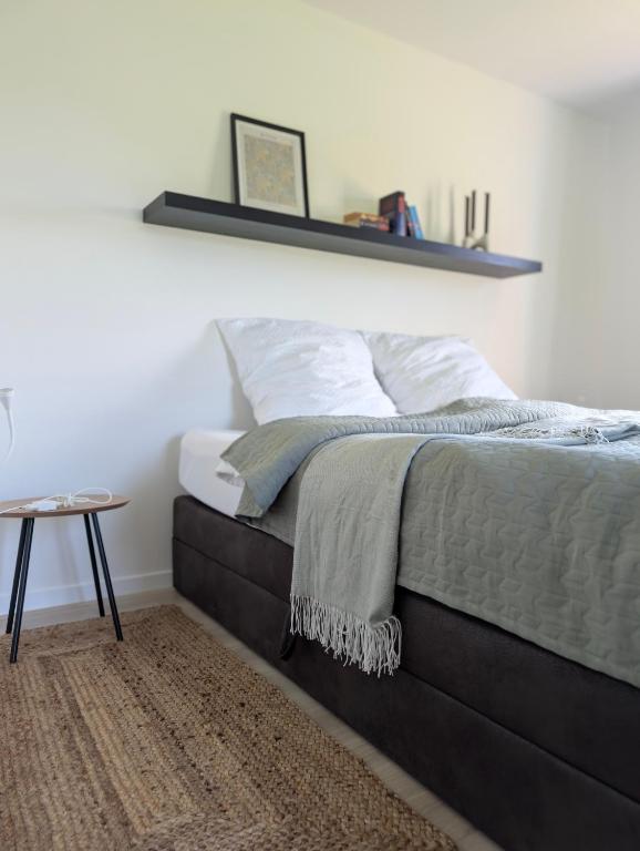 a bedroom with a bed with a shelf on the wall at FeWo Am Feldrand in Prebberede